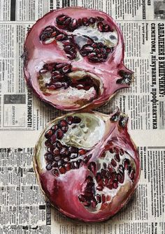 two pomegranates cut in half sitting on top of a newspaper