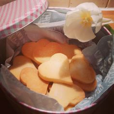 some heart shaped cookies in a tin with a flower