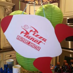 two paper lanterns hanging from the ceiling in a kitchen with other items on the counter