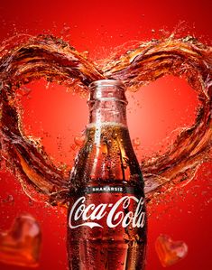 a coca - cola bottle in the shape of a heart with water splashing around it