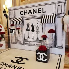 a chanel storefront with flowers and mannequins on display