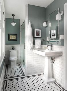 a bathroom with black and white flooring and gray walls is pictured in this image