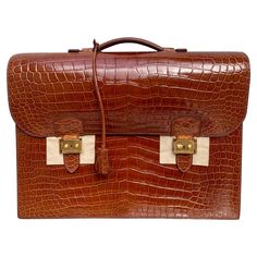 The Sac à Depeche briefcase from Hermès of Paris is one of the famed French luxury goods house's most coveted and exclusive items. This is a "Horeshoe Stamp" and this version carries a 6 year waiting list and is available by special order only for $90,000+. The ultimate unisex business accessory, the elegant model has long been a favorite of aristocrats, royalty, the international jet set and heads of state. One of a kind and only one in existence. This Hermes is bathed in a glazed Meil Brown He Mens Dress Hats, Italian Suit, French Luxury, Crocodile Bags, Waiting List, Vintage Hermes, Briefcase For Men, Travel Jewelry Case, Crocodile Skin