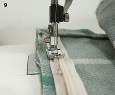 the sewing machine is working on the green and white material that has been sewn