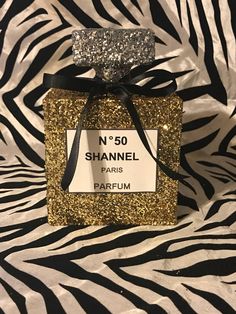 a bottle of perfume on top of a zebra print table cloth with a black ribbon