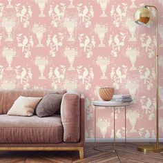 a couch sitting in front of a pink wallpaper with white birds on it's back