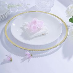 a white plate topped with a piece of cake on top of a table next to flowers