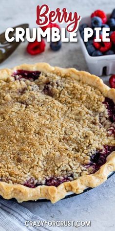 berry crumble pie on a table with berries in the background and text overlay that reads berry crumble pie