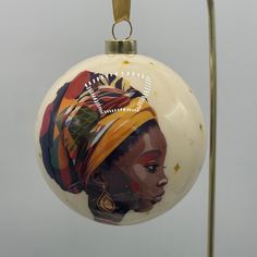 a glass ornament with a woman's head painted on the front and side