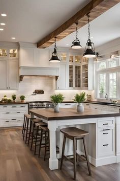 a large kitchen with white cabinets and wooden counter tops, along with two stools