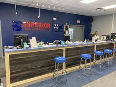 the front desk of a computer shop with blue stools