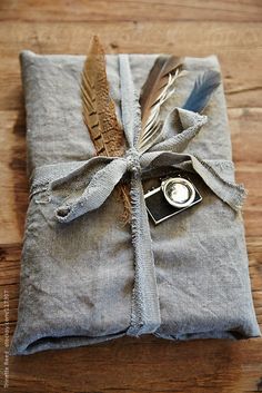 an old camera wrapped in linen with a feather on it