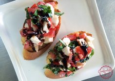 two pieces of bread with various toppings on them sitting on a white plate next to each other