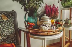 a wicker basket filled with flowers and teapots sitting on top of a table