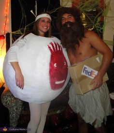 a man and woman dressed up in costumes posing for a photo with a fish costume on