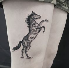 a black and white horse tattoo on the right side of the leg, it appears to be running