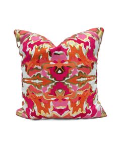 a pink and orange pillow with an abstract design on the front, sitting on a white surface