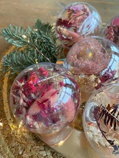 some glass balls with flowers in them on a table