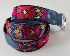 a colorful belt with metal buckles on it's end and a blue leather strap