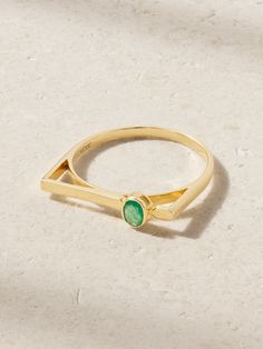 JIA JIA's ring has a unique cutout band with an extended bar that puts the 0.32-carat emerald on full display. It's handcrafted from 18-karat gold and looks especially cool on your index or middle finger. Modern Yellow Gold Emerald Ring For May Birthstone, Modern Yellow Gold Emerald Ring, Modern Diamond Ring For May Birthstone, Modern Yellow Gold Emerald Ring With Round Band, Modern May Birthstone Diamond Ring, Modern Baguette Cut Emerald Ring For May Birthstone, Modern Emerald Rings With Baguette Cut, Modern Yellow Gold Emerald Ring With Tension Setting, Modern May Birthstone Baguette Cut Jewelry