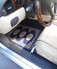 the interior of a car with an area rug on the floor and steering wheel cover