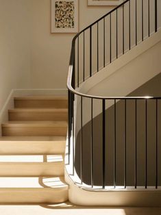 the sun shines on some stairs and railings in this home's entryway