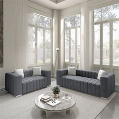 a living room with two couches and a coffee table in front of large windows