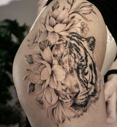 a woman's thigh with a tiger and flowers on it