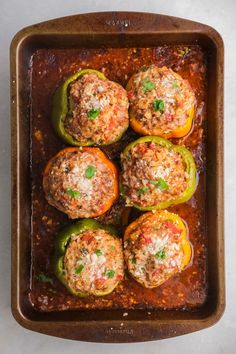 stuffed peppers in a baking dish with meat and seasoning on the top, ready to be eaten