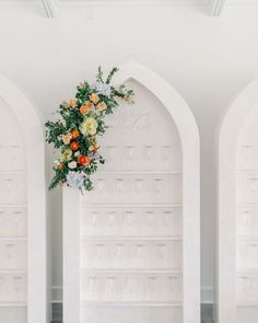 an arrangement of flowers and greenery decorates the walls of this elegant wedding venue