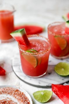 two glasses filled with watermelon margaritas and garnished with lime