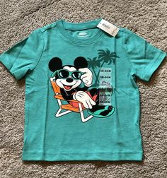 Brand new with tags. Toddler Baby Boys Old Navy Collectabilitees Tee Shirt. Size 18-24 months. Short Sleeves. Teal, turquoise Blue. Disney’s Mickey Mouse beach-themed graphic across front- “Endless Summer” Super soft jersey knit - 50% cotton; 50% polyester Fits children approximately 31-33” and 27-30 lbs. Please see all pictures. FAST FREE SHIPPING- same day or next depending on time of order. Packaged with care. From a clean, smoke-free/pet-free home. No returns. Disney Character Print Summer T-shirt, Disney Summer Cartoon Print T-shirt, Mickey Mouse Tops For Disney Trips In Summer, Playful Cotton Mickey Mouse T-shirt, Summer Disney Cotton T-shirt, Mickey Mouse Cotton T-shirt For Summer, Summer Cotton Mickey Mouse T-shirt, Summer Mickey Mouse Cotton T-shirt, Playful Mickey Mouse Tops For Summer