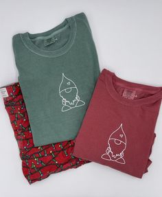 I absolutely LOVE this holiday tee. The Gnome Short Sleeve Tee is absolutely adorable and a great for the holidays. - One of the things I love about comfort colors is that their tees can be worn for really any occasion! I love this gnome tee paired with my Christmas shorts as a super cute pj set! The tee is SO SOFT!  Material: 100% Cotton, White Premium Heat Transfer Vinyl  Color: Red, Green Brand: Comfort Colors Fit: True to size, can be worn oversized or fitted :) ~ model 5'9 is wearing size: Christmas Cotton T-shirt For Loungewear, Christmas Cotton Top With Screen Print, Christmas Cotton Tops With Screen Print, Cute Winter T-shirt For Loungewear, Christmas Cotton Loungewear Tops, Soft-washed Crew Neck T-shirt As Gift, Gnome Shirts, Unisex Christmas Gifts, Green Brands