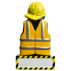 a yellow safety vest and hard hat on top of a sign