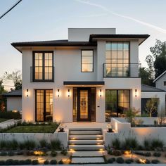 a white house with steps leading up to the front door and two story windows on each side