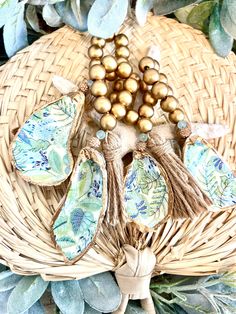 a wicker basket filled with lots of beads and tassels on top of leaves