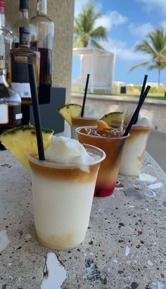 three drinks sitting on top of a table next to each other