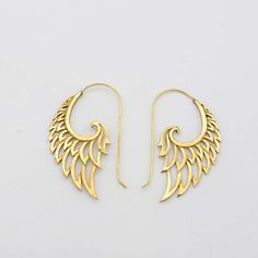 two pairs of gold toned earrings with wings on the ends, one is shaped like an angel's wing