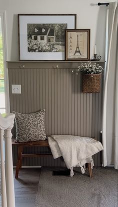 a bench with pillows and pictures on the wall above it, along with other decor