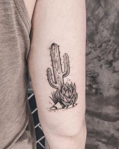 a small cactus tattoo on the left arm