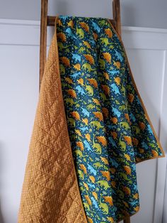 an orange and blue towel hanging from a wooden rack