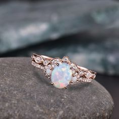 Oval Opal Ring, Vintage Opal Engagement Ring, White Opal Silver Jewelry, Gold Opal Ring, Women's Opal Ring, October Birthstone *Primary Stone: Fire Opal  *Stone Color: White *Stone Shape: Oval *Stone Size: 3x5mm *Secondary Stone Type: CZ Diamond, Fresh Water Pearl *Stone Size: 2mm *Stone Color: White *Stone Shape: Round This is a beautiful lab created white fire Opal engagement ring in 925 sterling silver. Main Stone: 6x8mm oval cut opal. Side stone: lab created opal + CZ diamond. Wedding band: Curved band, CZ diamond. This ring is marked S925/G10K/G14K. Features: * Handmade * Center Stone Opal  * Brand New * All Ring Sizes Available * Suitable For Every Day * 14k Solid Gold / 18k Solid Gold / Gold Filled Over Sterling Silver * Purity Stamped * Fits True to Size * High Quality * Available White Opal Oval Ring For Weddings, White Oval Opal Wedding Ring, Silver Oval Opal Wedding Ring, Oval Opal Ring With Halo Design For Wedding, Opal Wedding Ring Set, White Opal Engagement Ring, Fire Opal Engagement Ring, Vintage Opal Engagement Ring, Gold Rings For Women