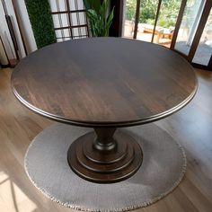 a round wooden table sitting on top of a hard wood floor