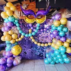 a mardi gras decoration with balloons and streamers