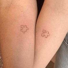 two people with matching tattoos on their legs, both have puzzle pieces tattooed on them