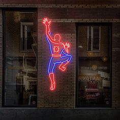 a neon sign that is on the side of a building in front of a window