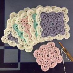 several crocheted doily are laid out on a table next to a pair of scissors