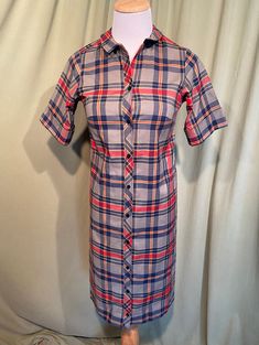 "This is a cute vintage dress from the 60's. No labels or tags. There isn't a size tag. The bust measures 30\", waist 30\", see measurements below. Made of gray, blue, red & yellow cotton blend, permanent press fabric. The dress is not lined. It has short sleeves, that can be worn cuffed or down. The collar is small. Buttons all the way down the front. The shape is very straight. A previous owner hand hemmed the hemline up 1.5\" & I left it up. Looks like it could be taken down without l Fitted Retro Vintage Dress With Button Closure, Fitted Plaid Retro Vintage Dress, Fitted Retro Plaid Vintage Dress, Retro Plaid Fitted Vintage Dress, Fitted Collared Shirt Dress With Covered Buttons, Fitted Collared Dress With Snap Buttons, Plaid Cotton Shirt Dress With Buttons, Plaid Buttoned Shirt Dress For Daywear, Plaid Shirt Dress With Buttons For Daywear