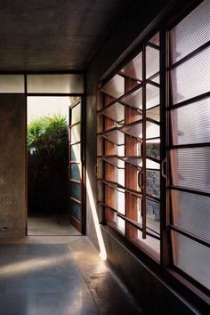 an empty room with open windows and plants in the window sill on either side