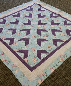 a blue and purple quilt on the floor